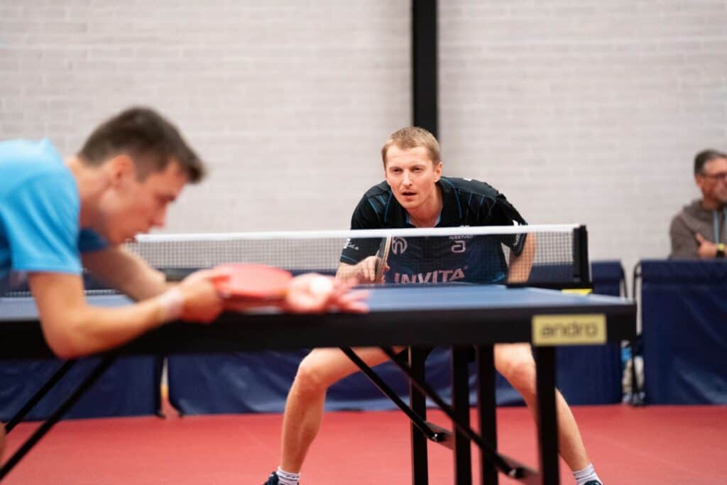 To mænd spiller ping pong i en turnering.