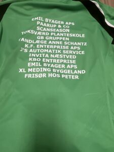 En grøn jakke med en liste med navne på.